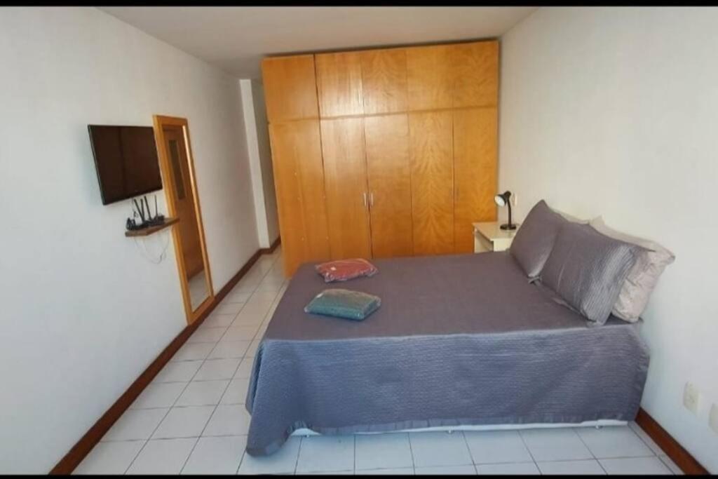 um quarto com uma cama grande e uma cabeceira em madeira em Studio aconchegante no coração do centro do RJ. no Rio de Janeiro