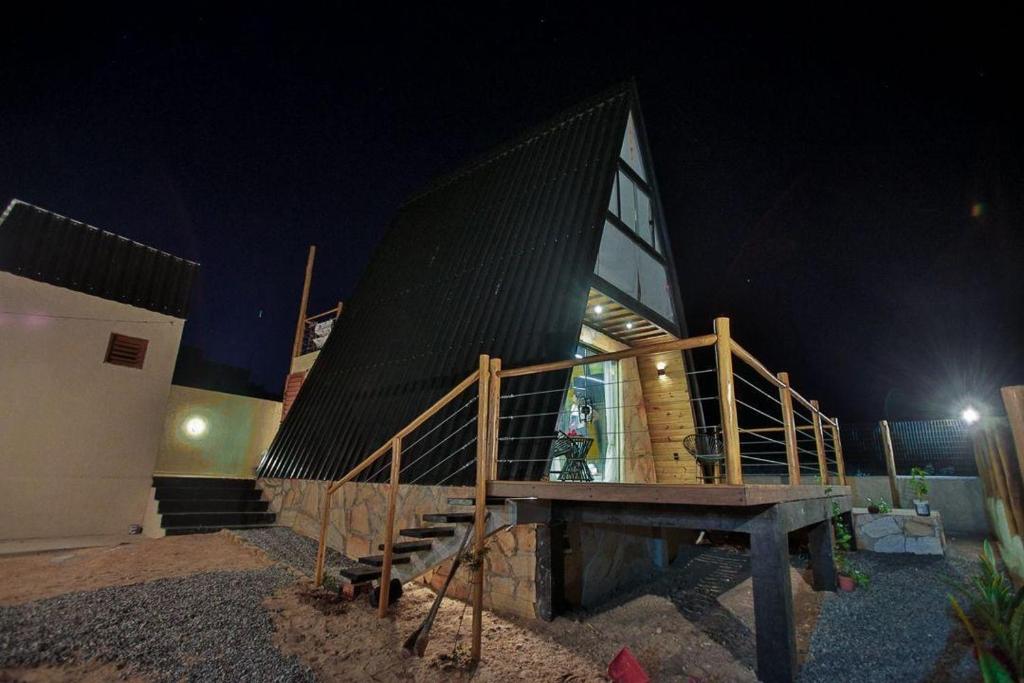 un edificio con una escalera de madera delante de él por la noche en Cabana Estrelas da Colina, en Serra de São Bento