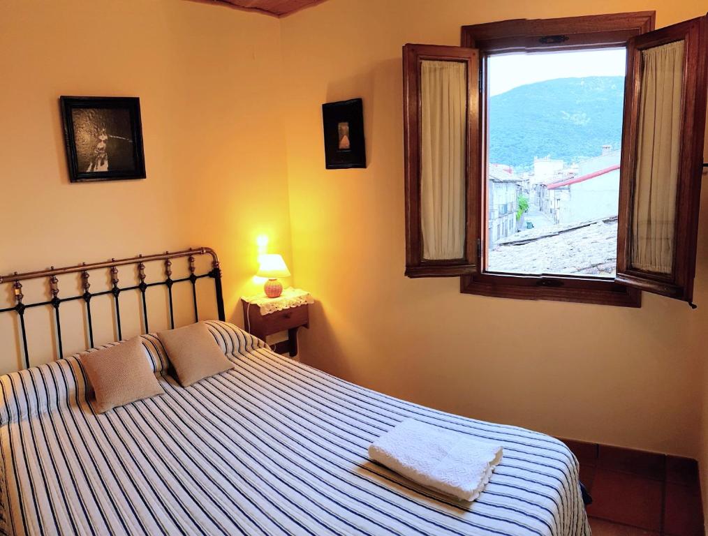 sypialnia z łóżkiem i dużym oknem w obiekcie Casa Rural TioMoreno by Naturadrada w mieście La Adrada