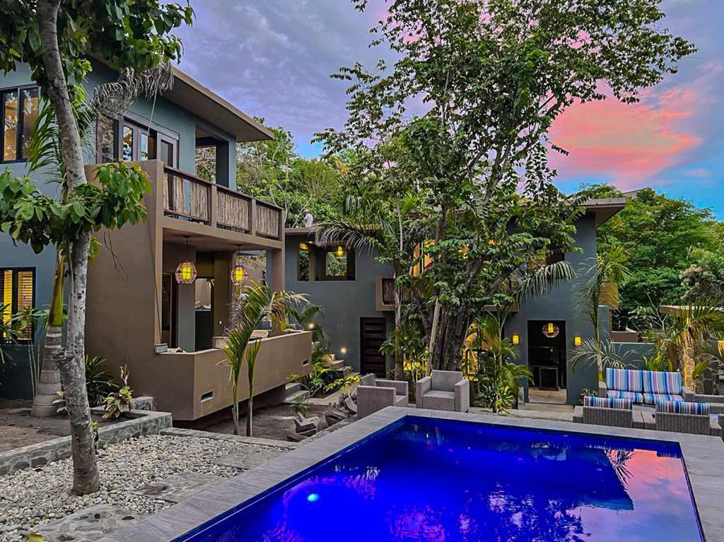 uma casa com uma piscina azul em frente a uma casa em Quinta Viajero em Zipolite