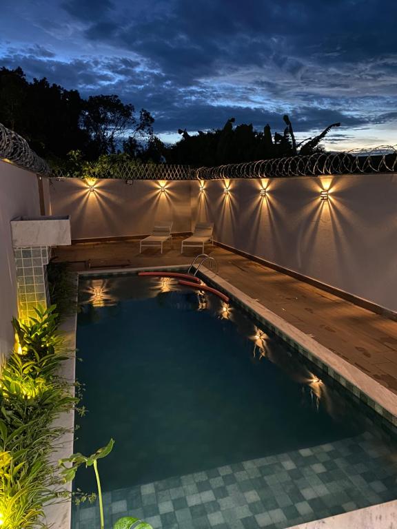 una piscina en un patio trasero por la noche en Aconchego! Sua casa com Piscina em Passos!!, en Passos