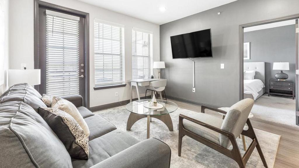 ein Wohnzimmer mit einem Sofa und einem TV in der Unterkunft Landing Modern Apartment with Amazing Amenities (ID2101X18) in Fort Worth