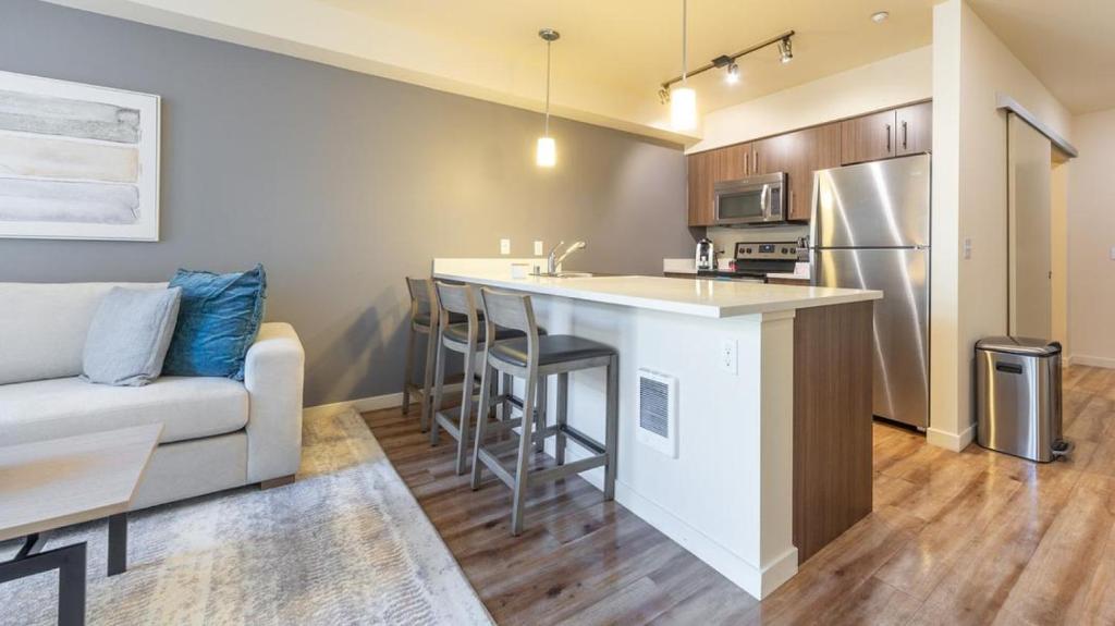 a living room with a couch and a kitchen with a counter at Landing Modern Apartment with Amazing Amenities (ID7286X92) in Tacoma