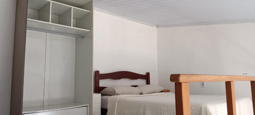a bedroom with white walls and a bed and a mirror at G.LO Loft AP 04 in Ponta Porã