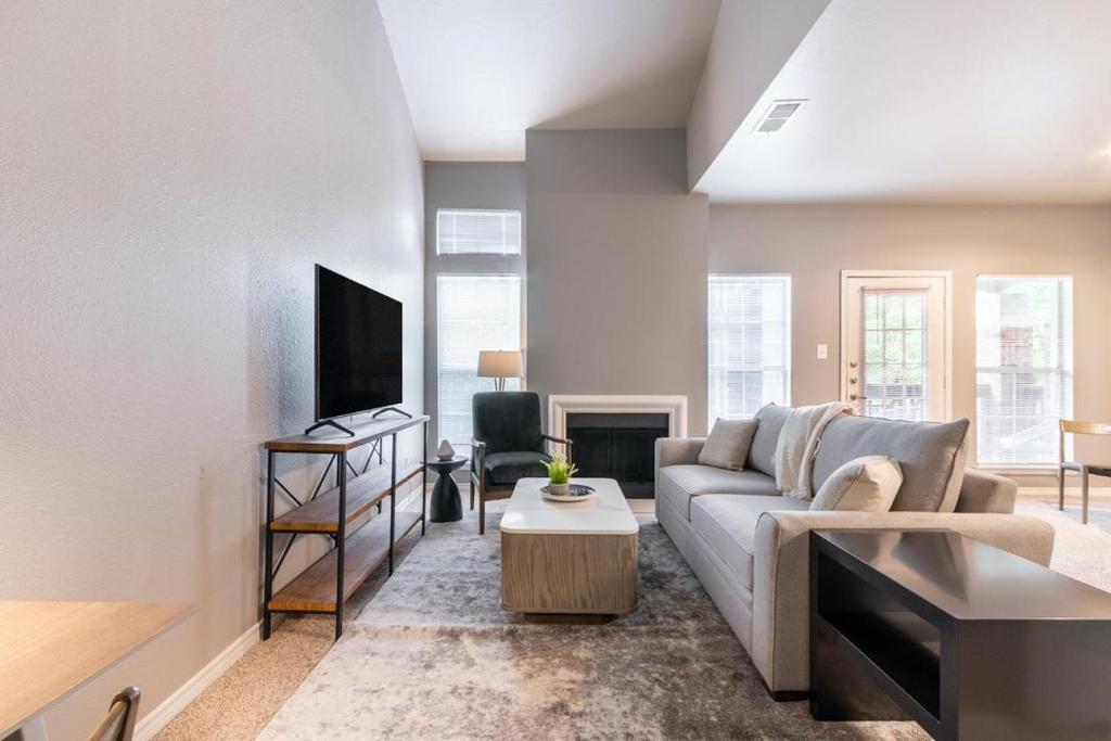 a living room with a couch and a tv at Landing Modern Apartment with Amazing Amenities (ID5301X35) in Irving