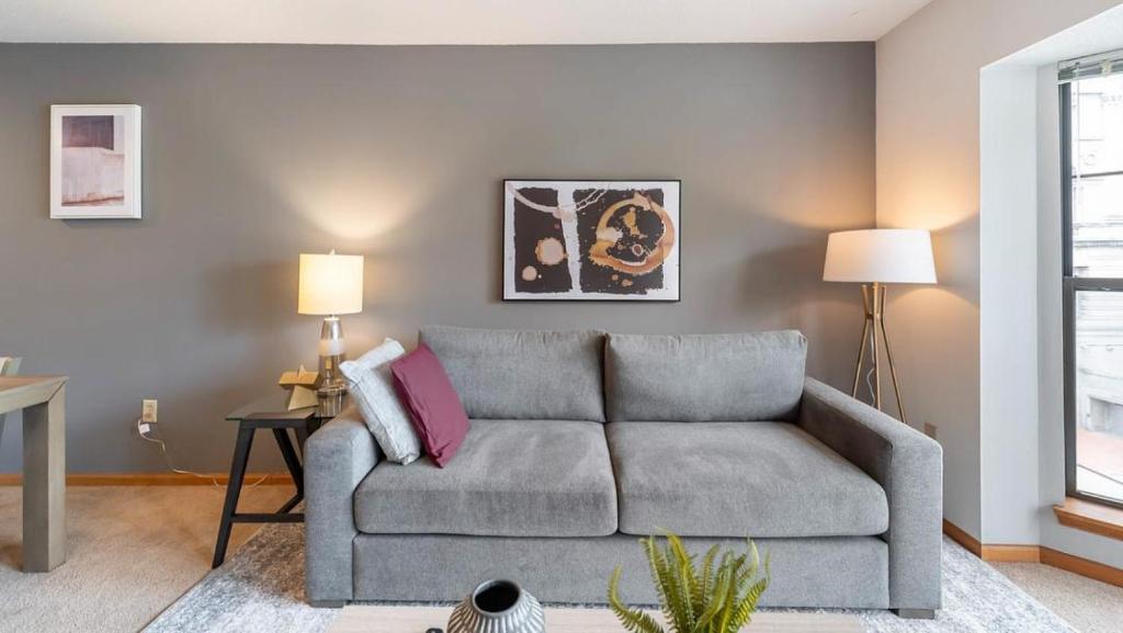 sala de estar con sofá gris y 2 lámparas en Landing Modern Apartment with Amazing Amenities (ID1223X281) en Milwaukee