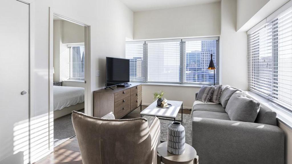 ein Wohnzimmer mit einem Sofa und einem TV in der Unterkunft Landing Modern Apartment with Amazing Amenities (ID9909X40) in Omaha
