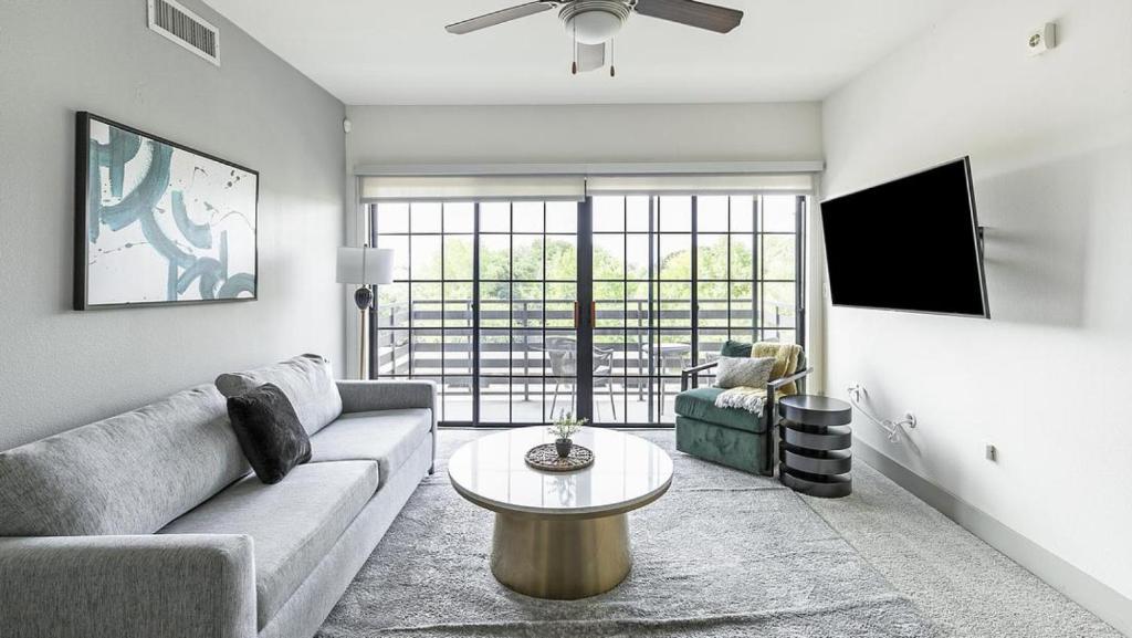 uma sala de estar com um sofá e uma mesa em Landing Modern Apartment with Amazing Amenities (ID1673) em Dallas