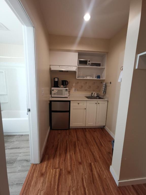 a small kitchen with a sink and a microwave at Coquihalla Motel in Hope