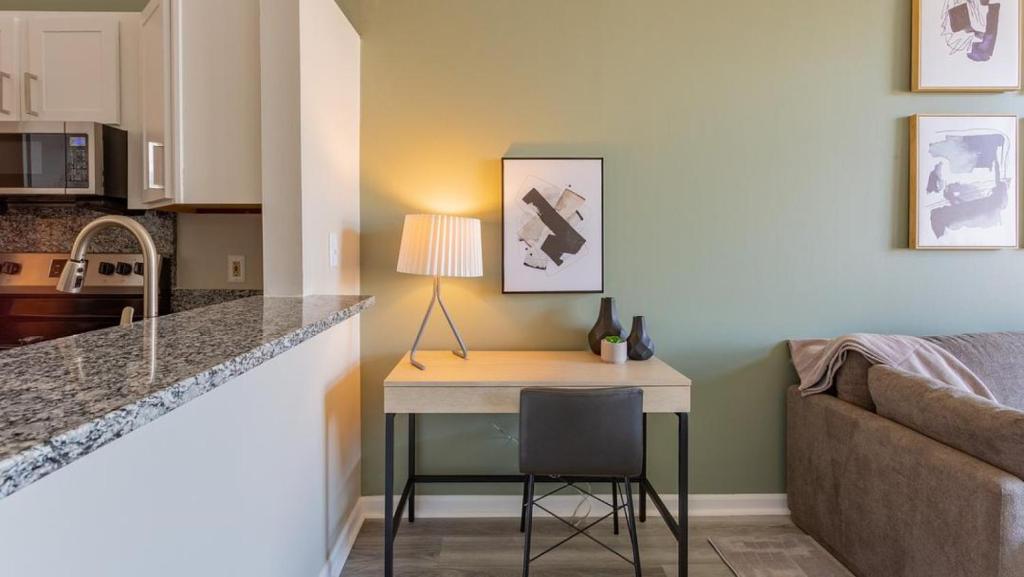 une petite cuisine avec une table et un canapé dans l'établissement Landing Modern Apartment with Amazing Amenities (ID1193X713), à Indianapolis