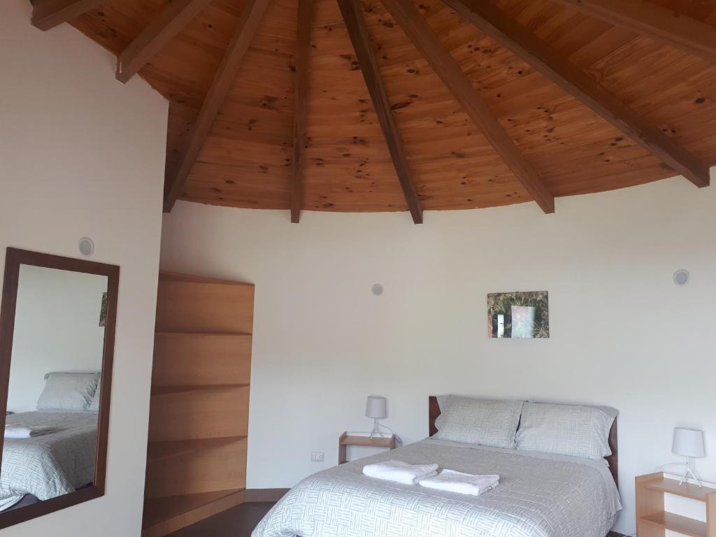 Schlafzimmer mit einem Bett und einem Spiegel in der Unterkunft Huaraz Lodge and Bungalows in Huaraz