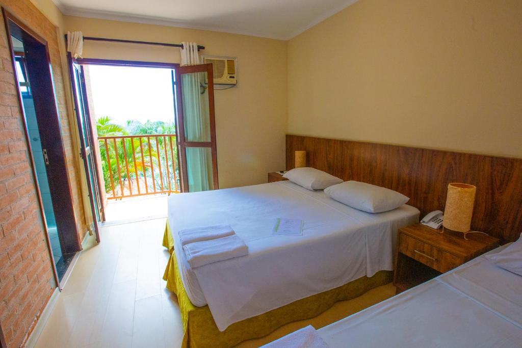 a bedroom with a bed and a large window at Pousada Iguatiba in Paraibuna