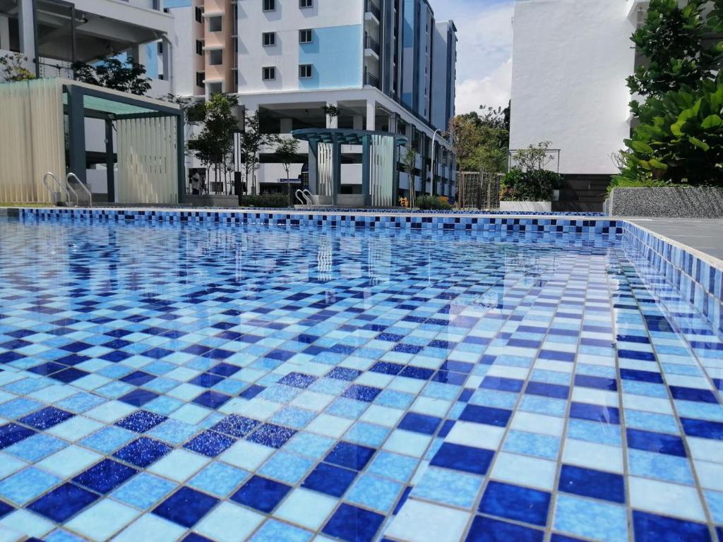 una piscina con azulejos azules y blancos. en Bayu Temiang Seremban- Your Urban Retreat en Seremban