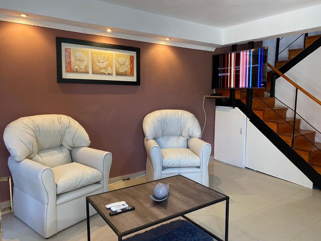 2 Stühle und ein Couchtisch im Wohnzimmer in der Unterkunft Apart Tommy Islas Malvinas y cacique catriel in Catriel