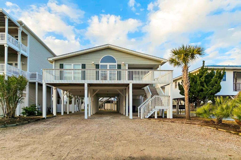 una grande casa con portico e vialetto di The Carolina Shell a Ocean Isle Beach