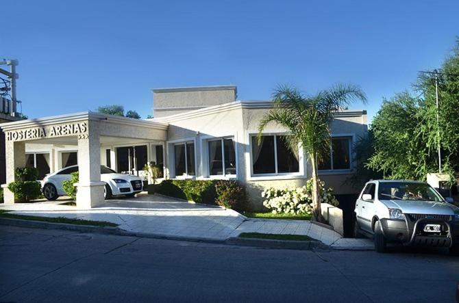 a house with a car parked in front of it at Hosteria Arenas in Mina Clavero