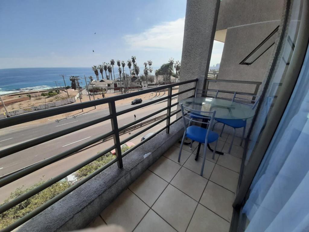 a balcony with a table and a view of the beach at VSM propiedades in Iquique