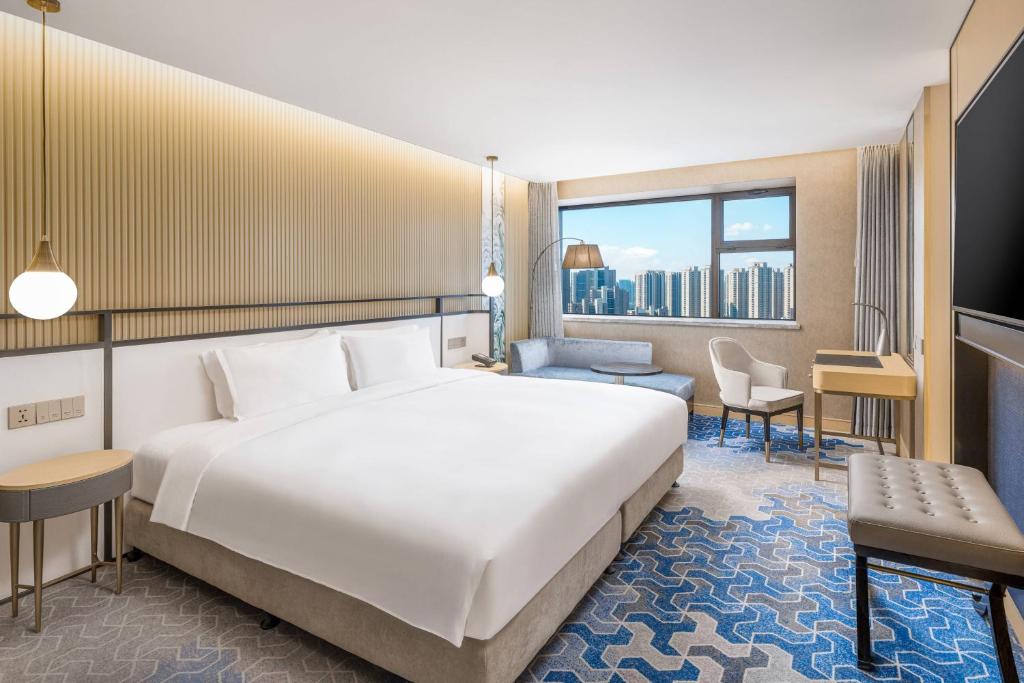 a hotel room with a bed and a large window at The Westin Shenyang in Shenyang