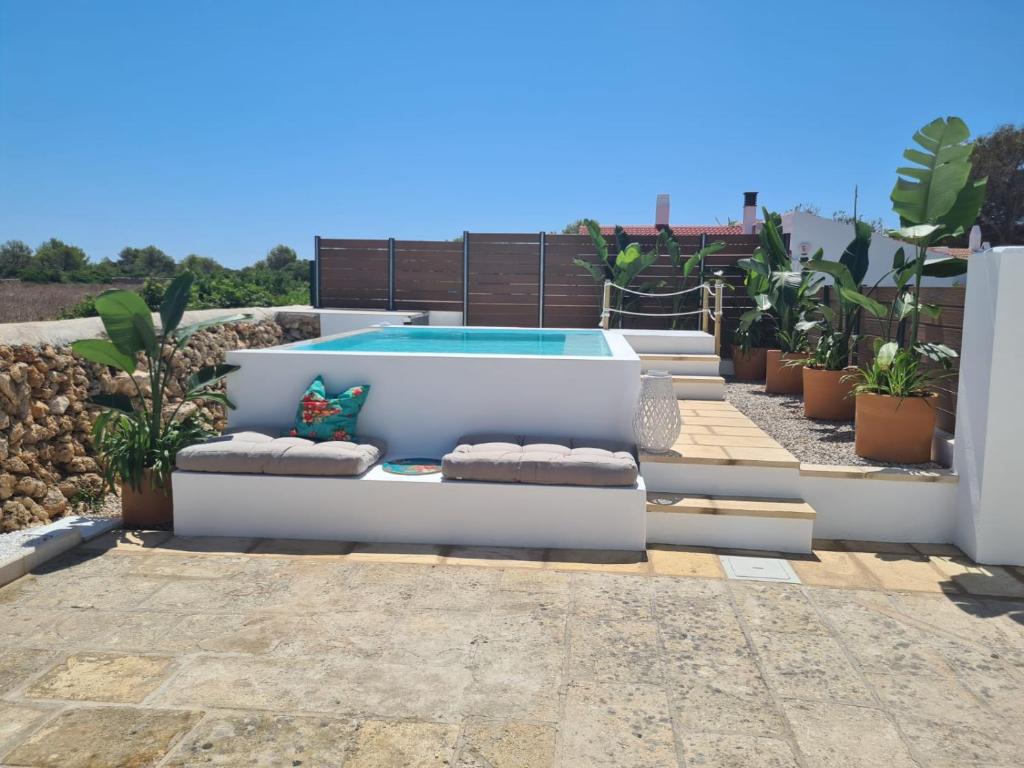 a pool on the roof of a house with plants at Apartamento nº 8 Cala Macarella in Cala Blanca