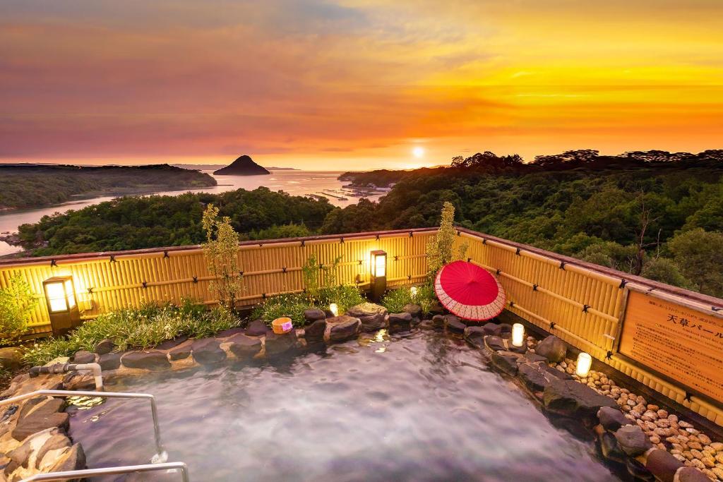 a hot tub with a view of the sunset at Ooedo Onsen Monogatari Amakusa Hotel Kameya in Kami Amakusa