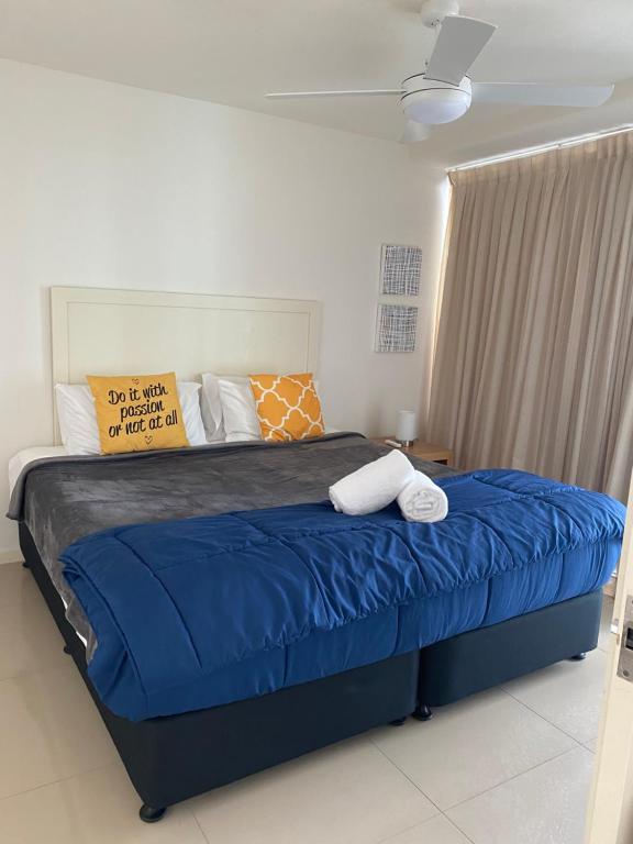 a bedroom with a large bed with blue sheets and pillows at Cilento Mooloolaba in Mooloolaba