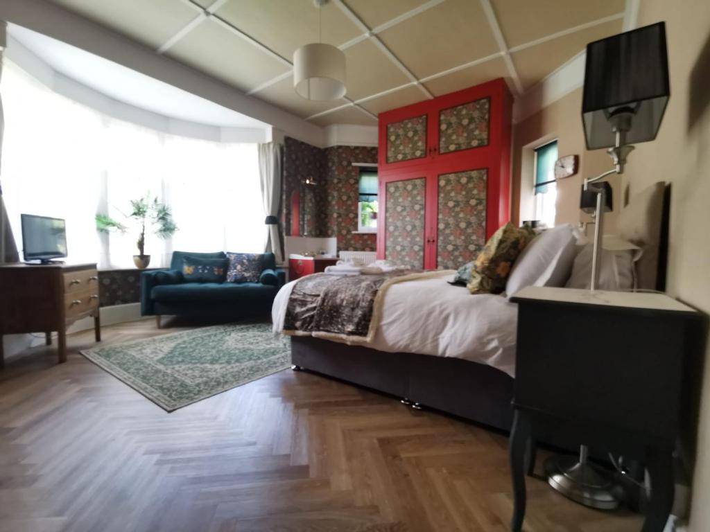 a bedroom with a bed and a living room at William Morris, Spacious ground floor lux double bedroom in Bexhill