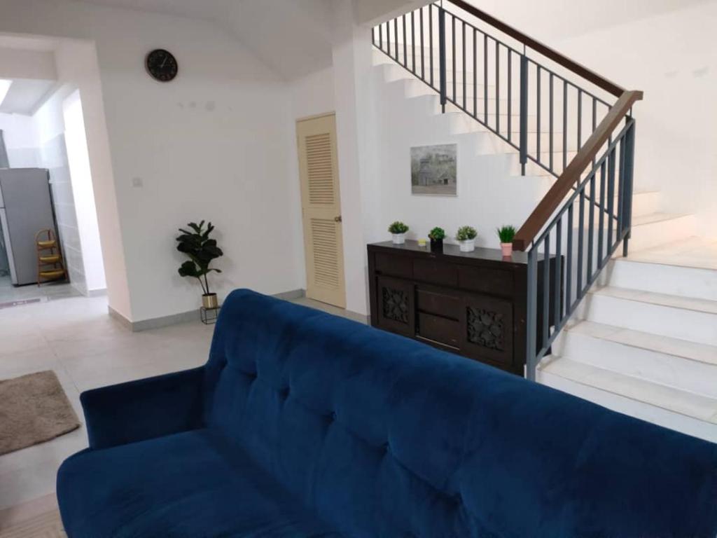 - un canapé bleu dans le salon avec des escaliers dans l'établissement Sierra Hill Homestay 2, 