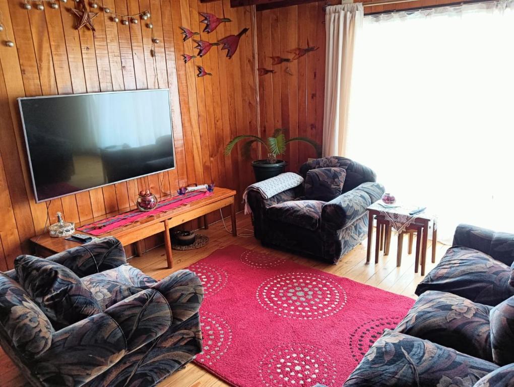 Il comprend un salon avec des canapés et une télévision à écran plat. dans l'établissement Casa en sector isla teja, à Valdivia