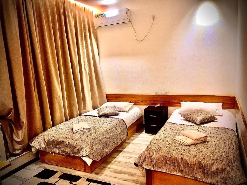 Zimmer mit 2 Betten und einem Fenster in der Unterkunft Maryam hotel in Samarkand