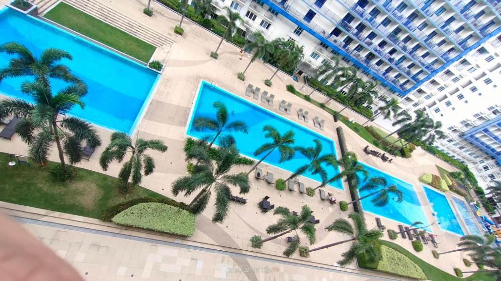 - une vue sur un complexe avec des palmiers et un bâtiment dans l'établissement Sea Residences - Rheiyn, à Manille