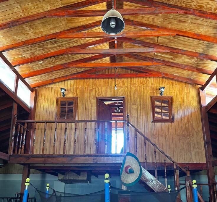 Habitación grande con techo de madera y ventilador. en Rancho.JC, en Colbún