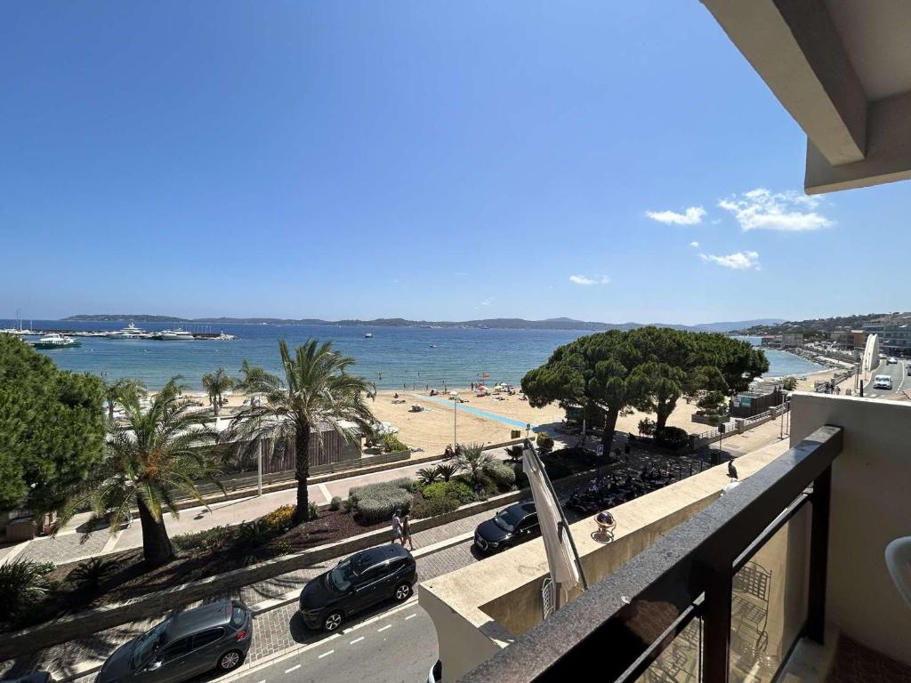 un balcon avec vue sur une plage et des voitures dans l'établissement Appartement 2 pièces Sainte-Maxime proche plage avec parking et climatisation - FR-1-226-533, à Sainte-Maxime