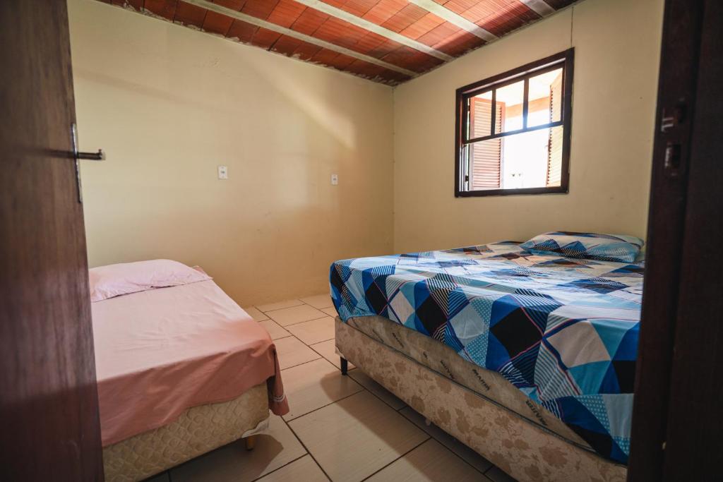 - une chambre avec 2 lits et une fenêtre dans l'établissement Pousada Salinas Valle, à Tramandaí