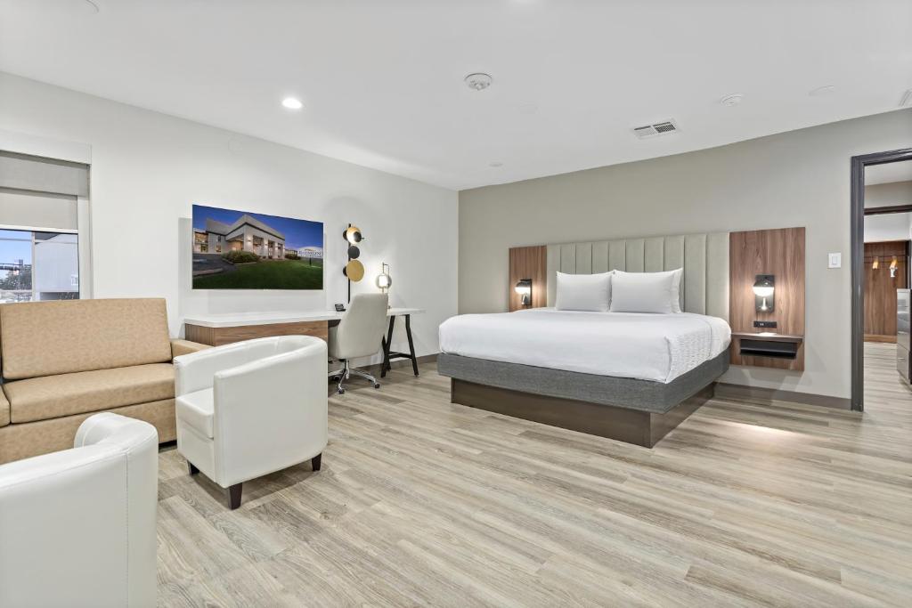 a hotel room with a bed and a desk at Baymont by Wyndham Beaumont in Beaumont