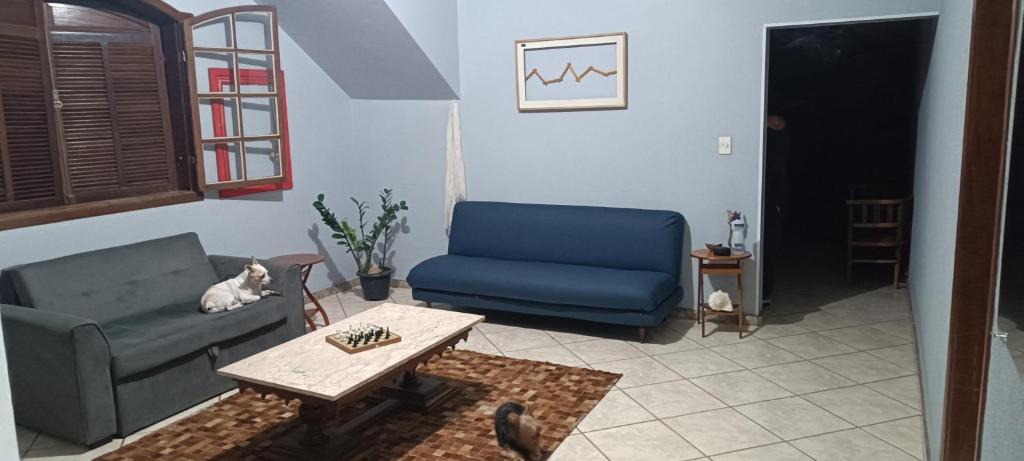 a living room with a blue couch and a table at Hostel Kinu in Belo Horizonte