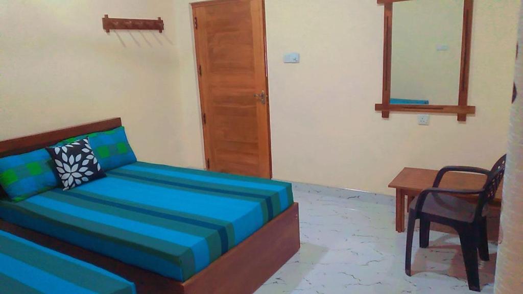 Arana Holiday Resort في Kurundankulama: غرفة بها أريكة وطاولة وكرسي