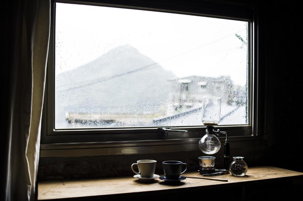 a window with a table with cups and a wine glass at Shabby Home 28 in Jiufen