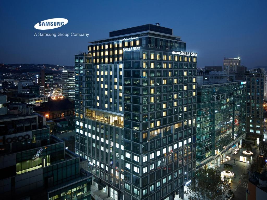 首爾的住宿－Shilla Stay Gwanghwamun Myeongdong，一座高大的建筑,晚上在城市里亮着灯