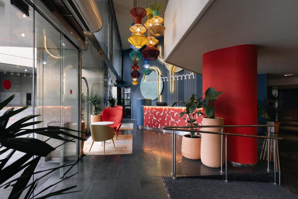 un hall avec une table, des chaises et des plantes dans l'établissement Hotel Indigo Barcelona Plaza Espana, an IHG Hotel, à Barcelone