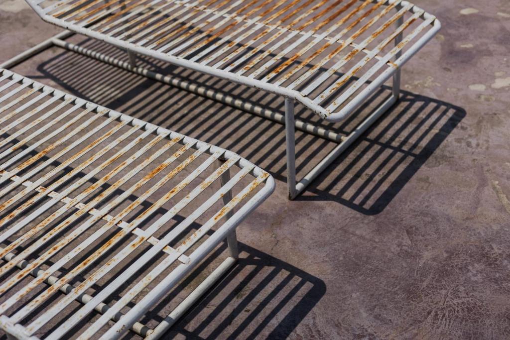 トゥクトゥクにあるGokhon Guest Houseの二つの金属製のベンチが並ぶ歩道