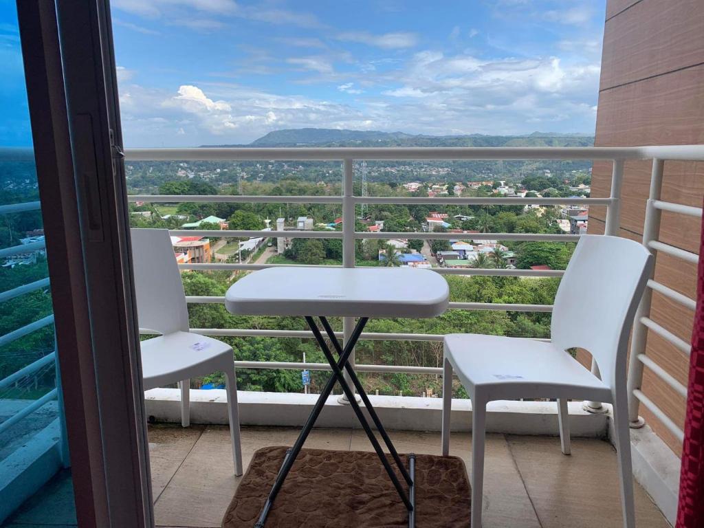 two chairs and a table on a balcony with a view at Uptown Condominium Primavera Residences in Cagayan de Oro
