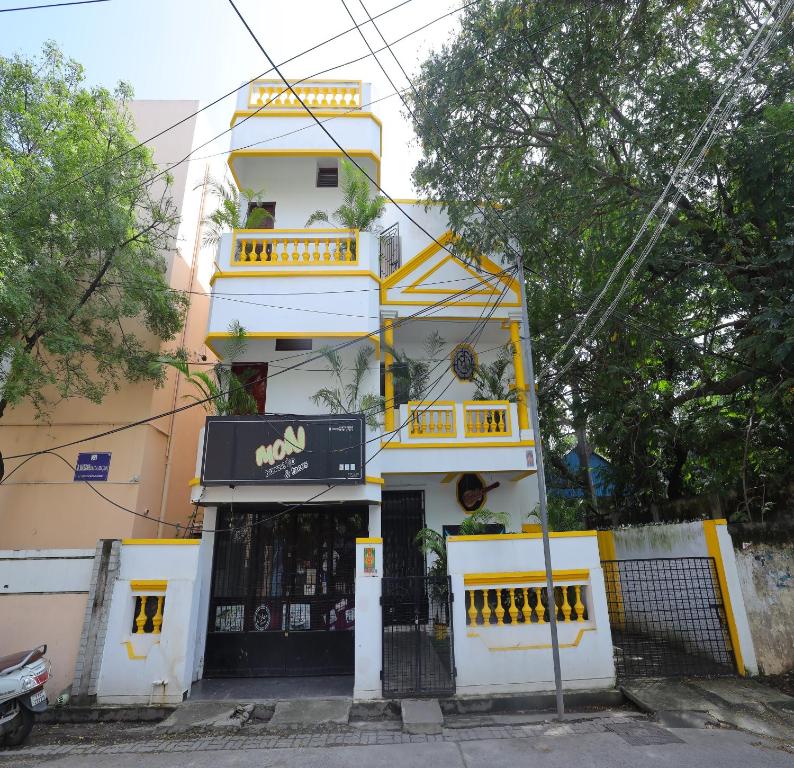 un edificio giallo e bianco con un negozio di SJ Villa a Pondicherry