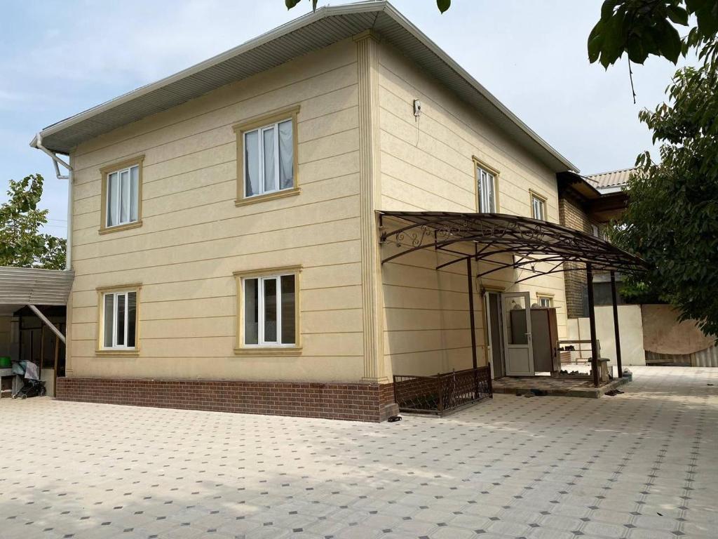 a large house with a large driveway in front of it at Sunny Guest House in Osh