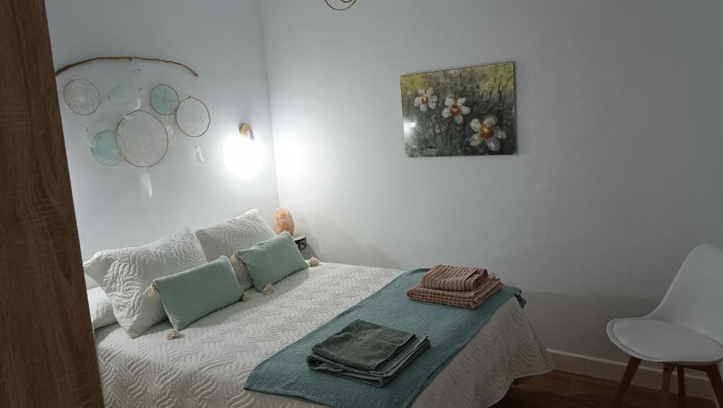 a bedroom with a bed with a picture on the wall at La casita de los mandalas in Cazorla