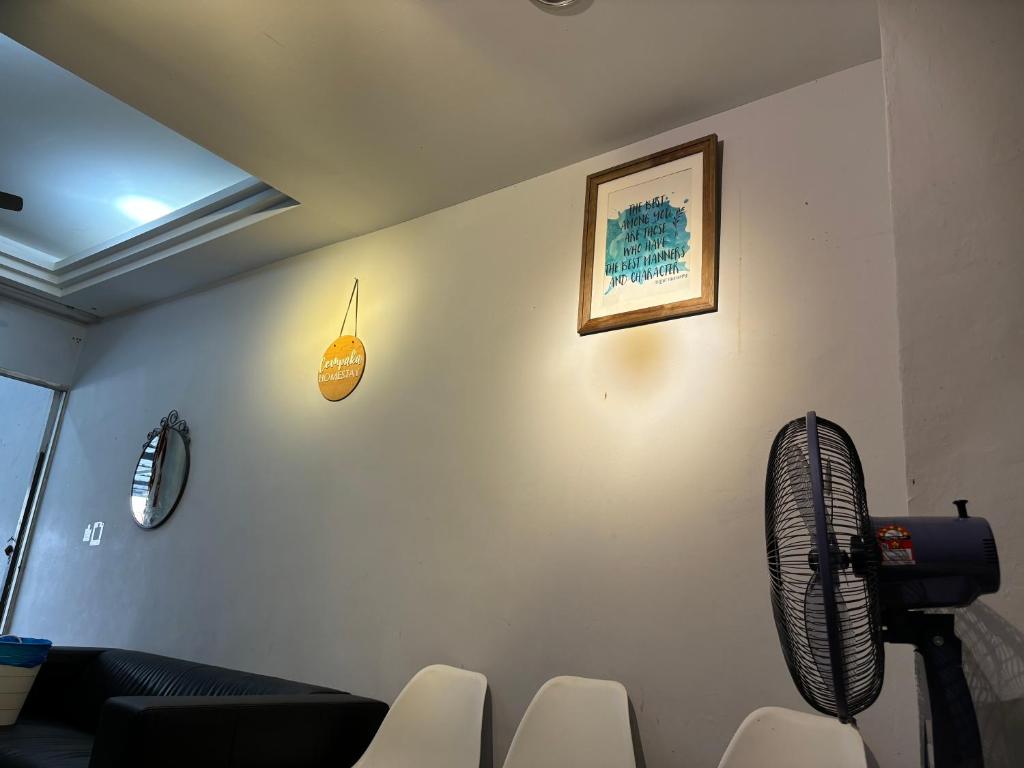 峇株巴辖Cempaka Homestay Batu Pahat 93的客厅配有沙发和壁挂式风扇