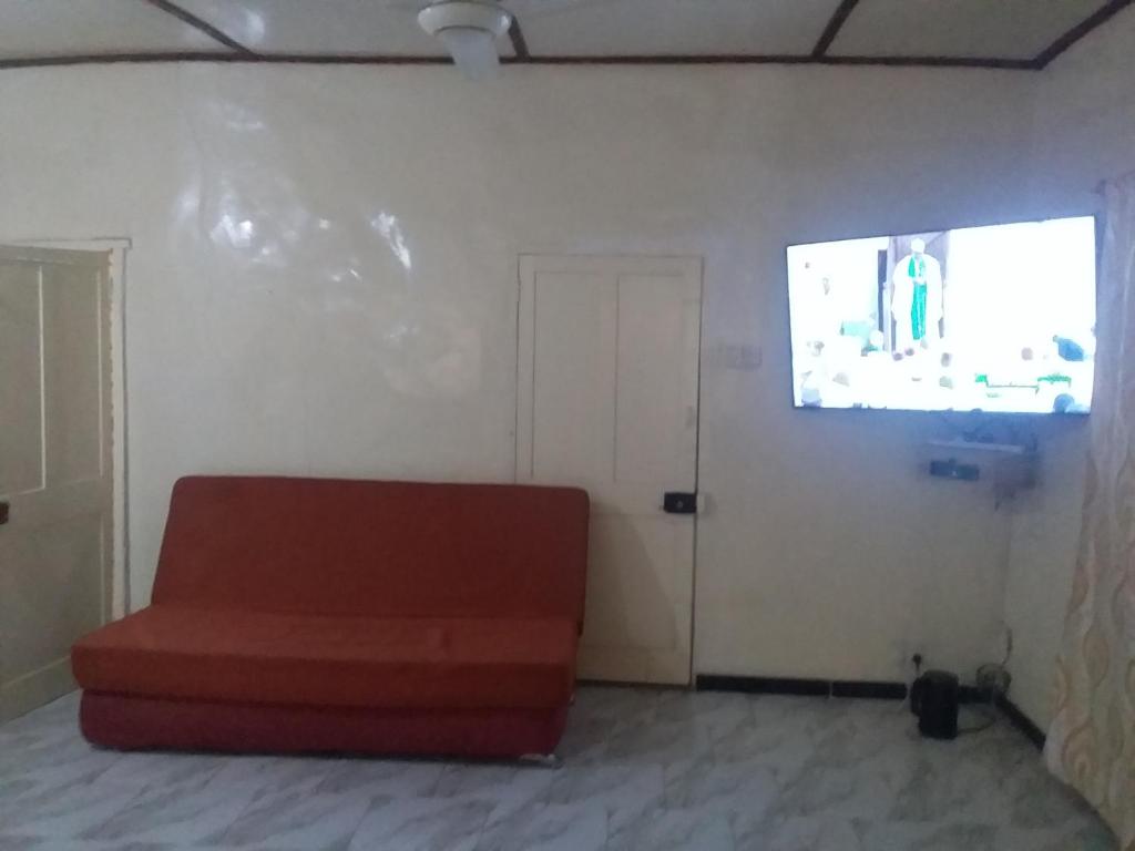 a living room with a red couch and a screen at Limbas Luxury Appartements 2 in Bakau