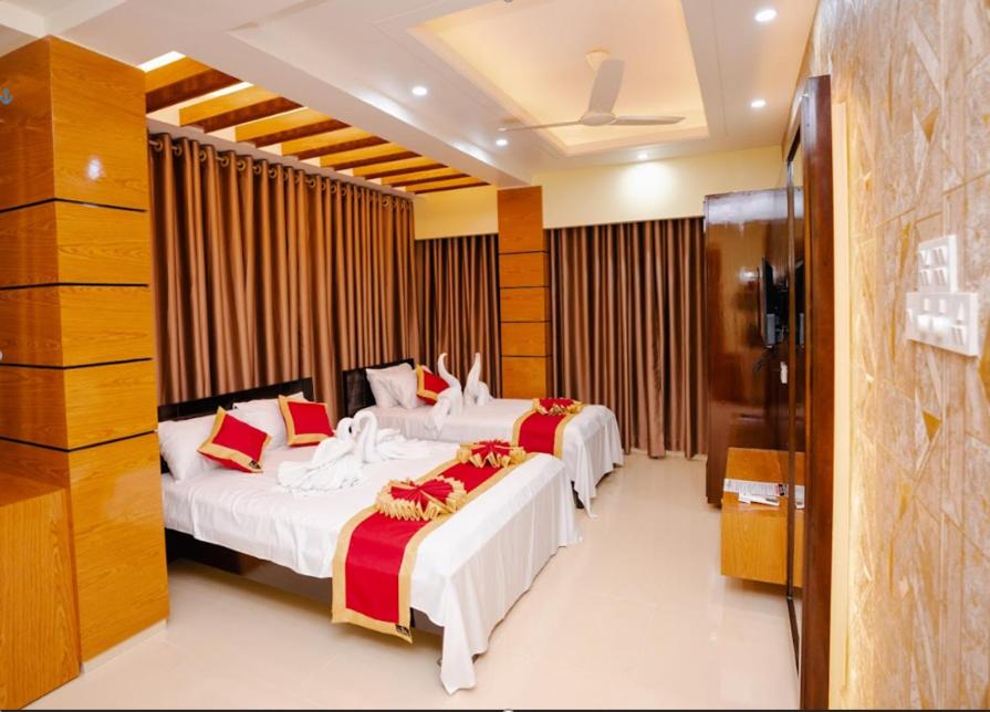 a hotel room with three beds and a television at Adarsha Palace Hotel in Chuknagar