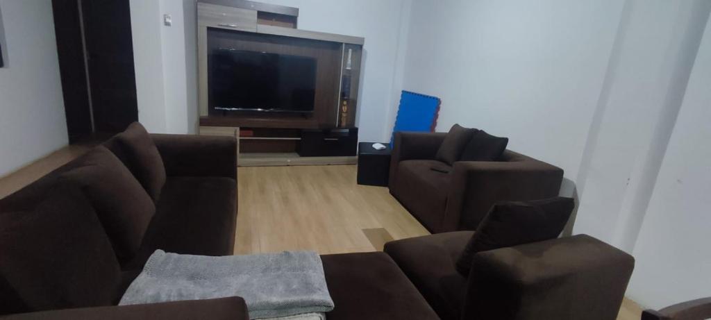 uma sala de estar com 2 sofás e uma televisão de ecrã plano em DEPARTAMENTO AMOBLADO em Cajamarca