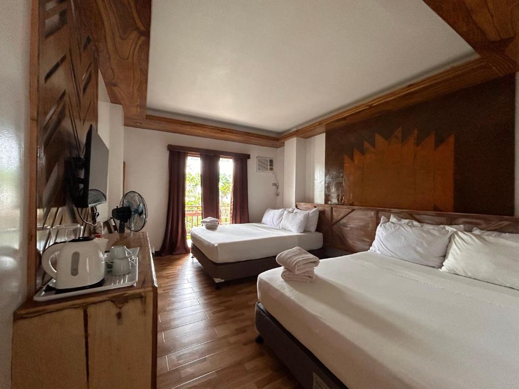 Habitación de hotel con 2 camas y sofá en Puyo Suites Homestay, en General Luna