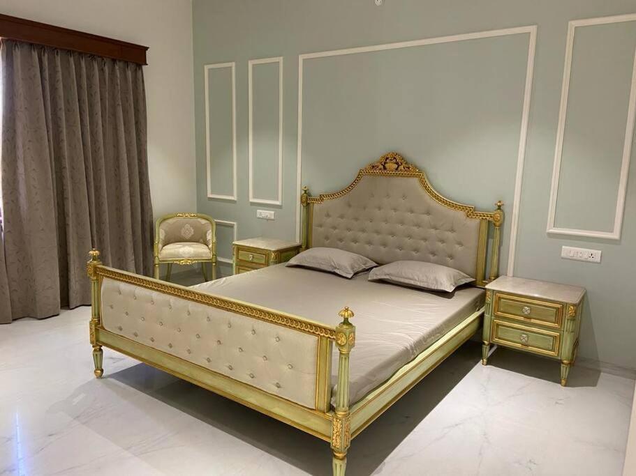 1 dormitorio con 1 cama con marco dorado y 2 sillas en LUXURY HOMES nearest to lakes and old city, en Udaipur